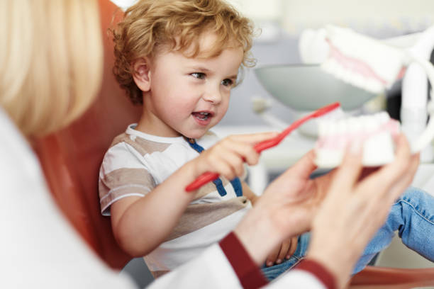 Teaching child to taking care of teeth stock photo
