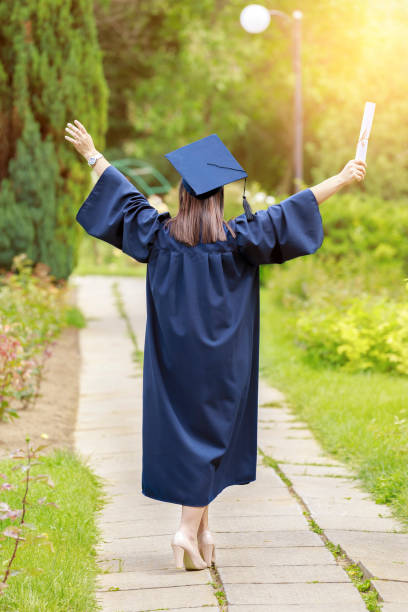 istock Young woman in graduation day celebrating 694854948