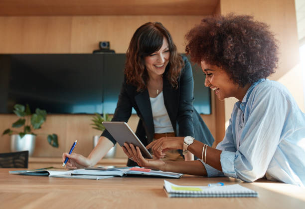 creative femmes cadres à l’aide de tablette numérique au bureau - business meeting teamwork office happiness photos et images de collection