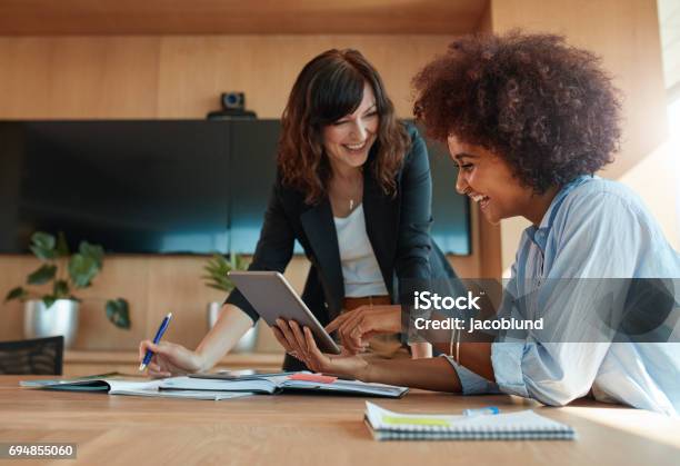 Creative Female Executives Using Digital Tablet In Office Stock Photo - Download Image Now