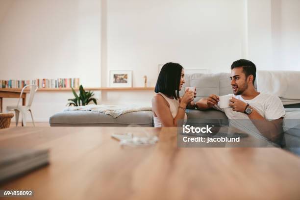 Photo libre de droit de Jeune Couple Buvant Le Café À La Maison banque d'images et plus d'images libres de droit de Jeune couple - Jeune couple, Tous types de couple, Vie domestique