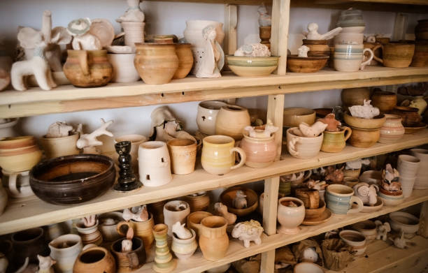 istock many different pottery standing on the shelves in a pottery workshop. Low light 694872380