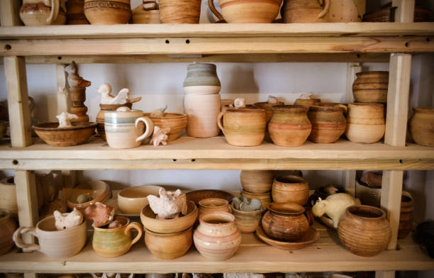 istock many different pottery standing on the shelves in a pottery workshop. Low light 694872446