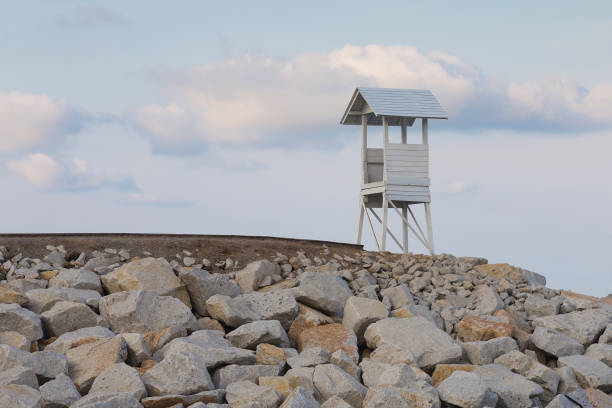 istock Wooden White lifeguard over rock coastline 694879878