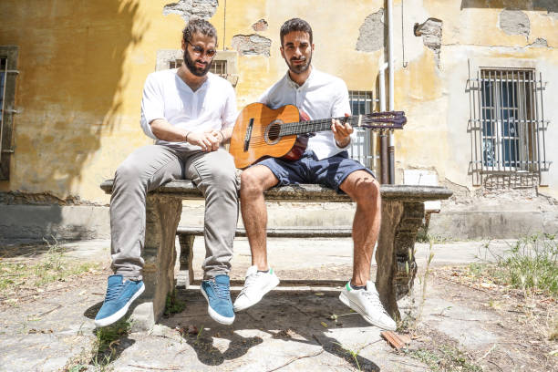 istock Two adult men playing guitar together 694886660