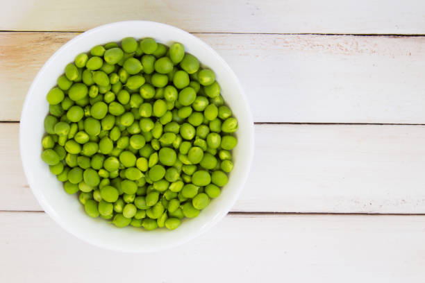 istock Fresh green peas on a wooden table 694897940