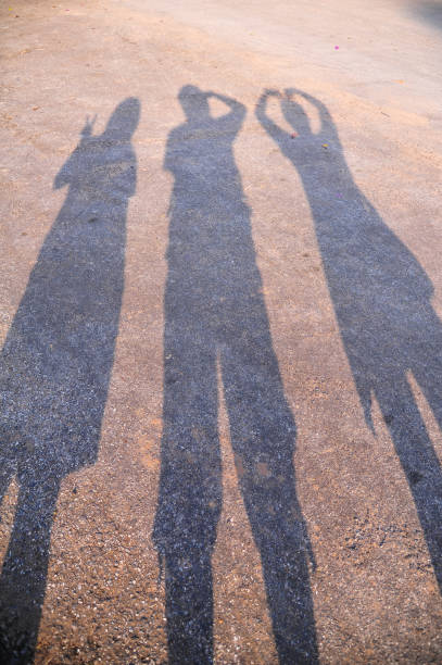 istock Shadow of three people action posting on ground 694900520