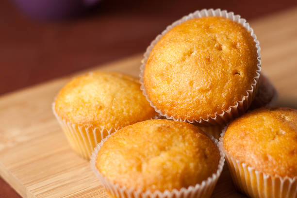 istock Fragrant cupcakes lie on a wooden table. 694903142