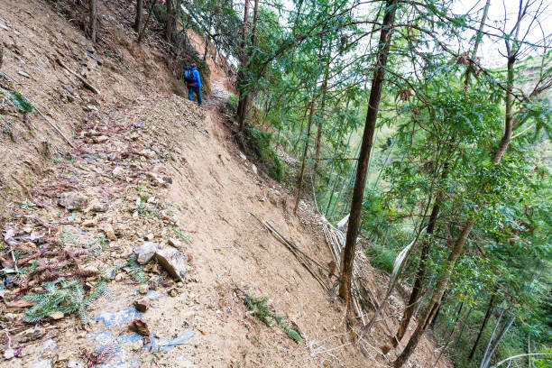 istock tourist walks on path through mudslide on mountain 694903838