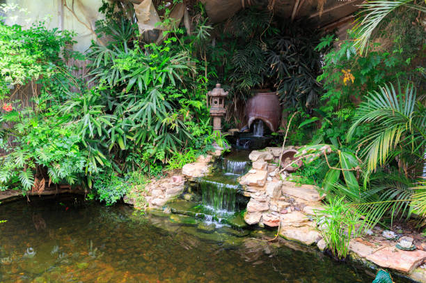 piccola cascata nello stagno decorativo - fountain in garden foto e immagini stock