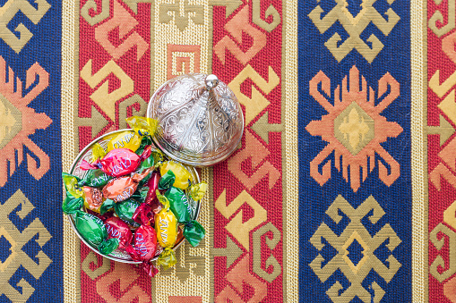 Colorful candies on turkish carpet top view