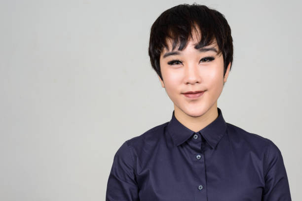Studio shot of young Asian transgender teenage boy against gray background Studio shot of young Asian transgender teenage boy against gray background horizontal shot trans boy stock pictures, royalty-free photos & images