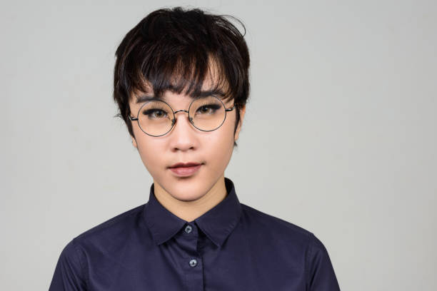 Studio shot of young Asian transgender teenage boy against gray background Studio shot of young Asian transgender teenage boy against gray background horizontal shot trans boy stock pictures, royalty-free photos & images
