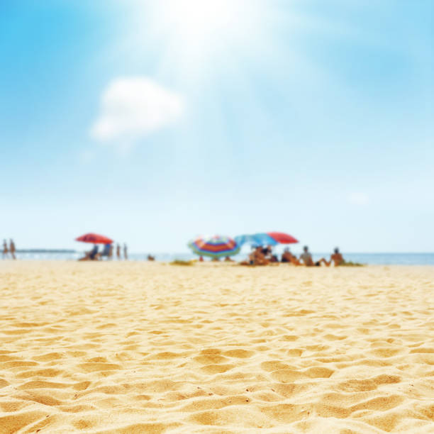 istock sand beach with peoples and sun in clouds 694915836