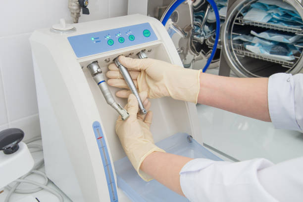 istock Instrument sterilization and cleaning in dentistry, nurse using automatic instrument maintenance equipment to clean turbines and handpieces, closeup shoot. 694916188