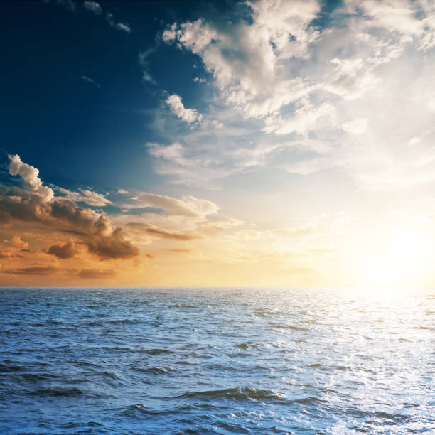istock dark sea and sunset in cloudy sky 694924452