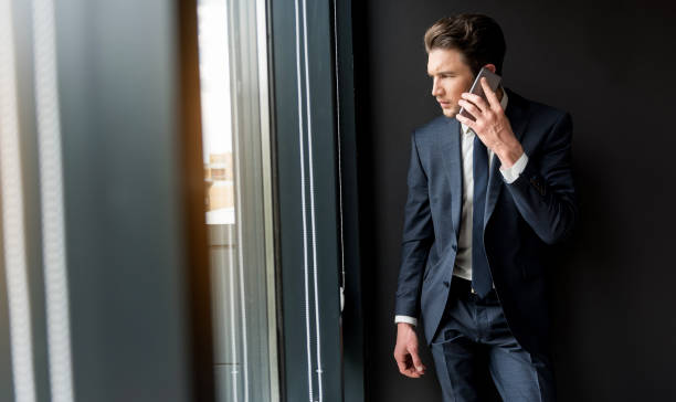 istock Depressed cheerless businessman is talking on smartphone 694924850