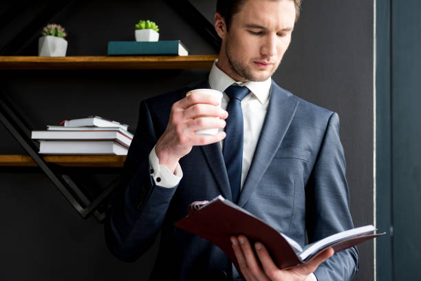 istock Young confident businessman is standing with notepad 694927584