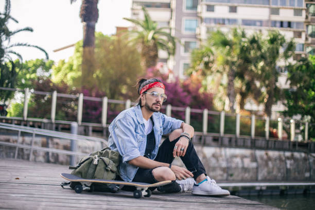istock Skater man in park sitting 694927632