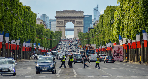 The view of the Triumphal arch to the Champs-Elysees. The avenue is one of the most famous streets in the world for upscale shopping and popular tourist attraction of Paris.