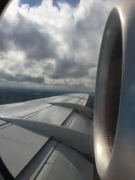A view out the window of a passenger airfraft.  The large jet engine right beside the window.