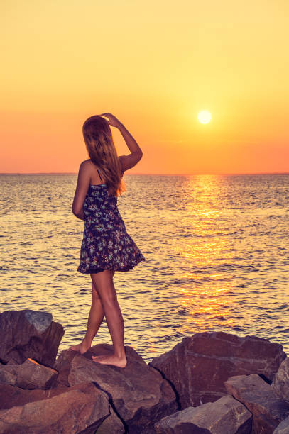 istock Young Woman Watching Sunset 694945150