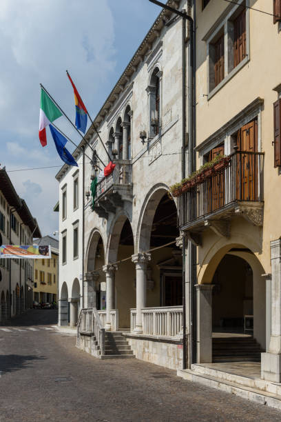Gemona del Friuli,City Hall Main Street Gemona,Friuli, Italy - June 02, 2017: Flags flutter in the restored town hall after the 1976 earthquake gemona del friuli stock pictures, royalty-free photos & images