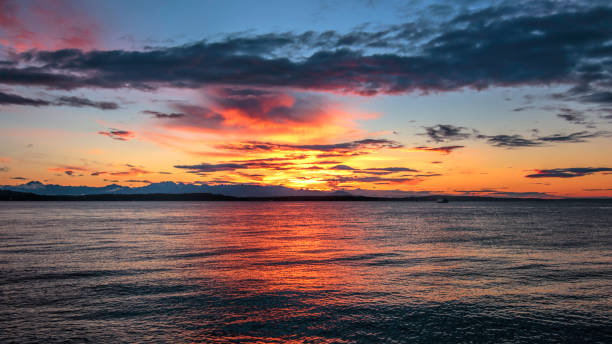 istock Alki Beach Sunset with Olympic Range Silhouetted and Water Reflections. 694952768