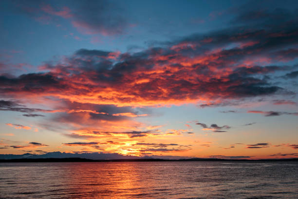 istock Sunset with Orange and Red in Storm clouds and Water Reflection 694952810