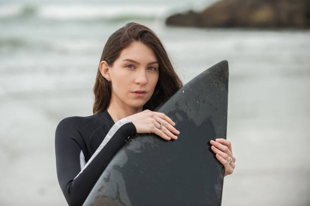 istock Young female surfer and her black board. 694963464