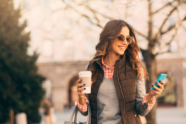 istock Woman texting and drinking coffee outdoors. 694977140