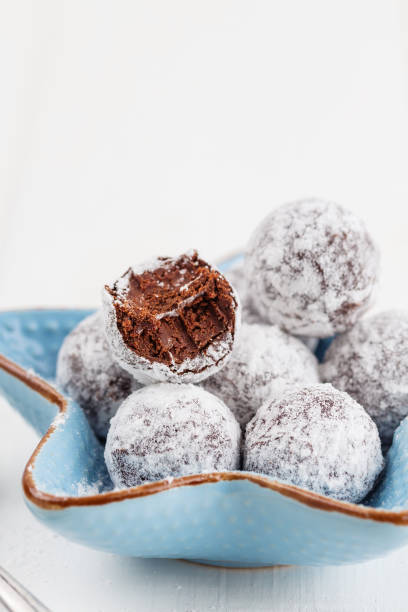 istock Bitten chocolate truffle in sugar powder 694977616