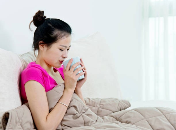 istock Sick woman holding  cup of tea 694982606