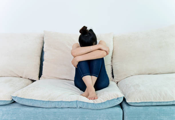 istock Young woman hiding her face in her knees 694982814