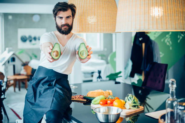 istock Handsome bearded man making avocado meal in the kitchen 694983104