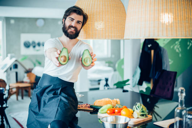 istock Handsome bearded man making avocado meal in the kitchen 694983152