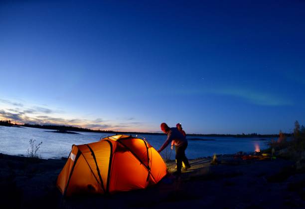Tent glowing. A young couple's tent glows in the Northwest Territories on an expedition on Great Slave Lake. great slave lake stock pictures, royalty-free photos & images