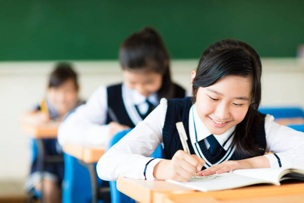 sourire de fille étudiante dans la salle de classe et ses amis en arrière-plan - Photo