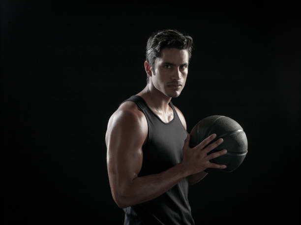 istock Man Holding a Basketball On A Black Background 695009438