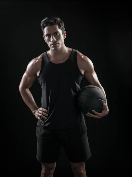 istock Man Holding a Basketball On A Black Background 695009554