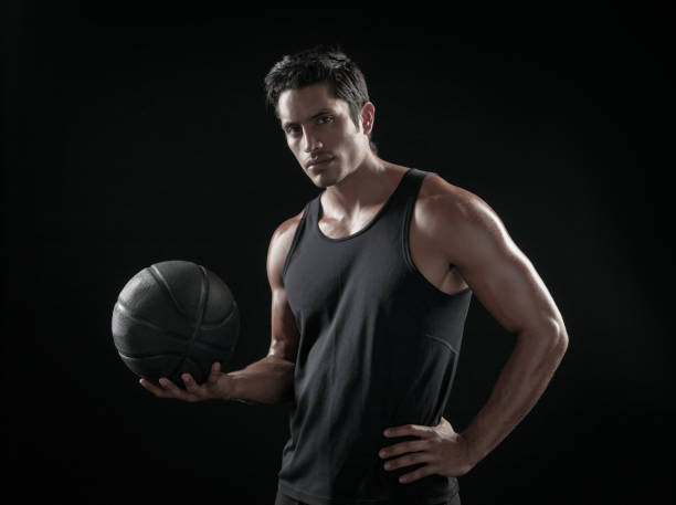 istock Man Holding a Basketball On A Black Background 695009600