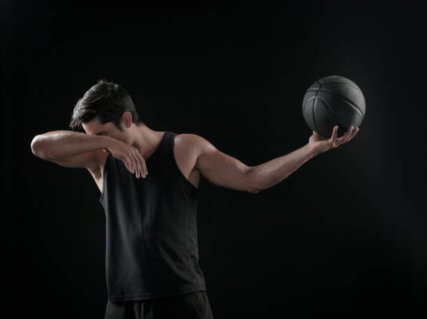 istock Man Holding a Basketball On A Black Background 695009750