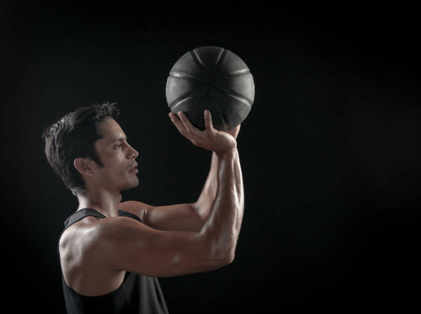 istock Man Holding a Basketball On A Black Background 695009940