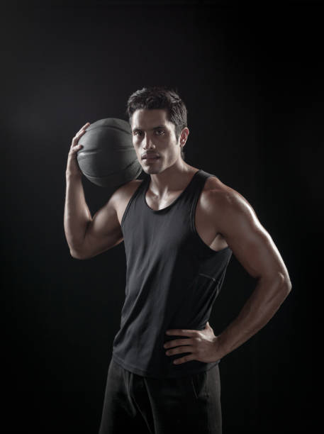 istock Man Holding a Basketball On A Black Background 695010008