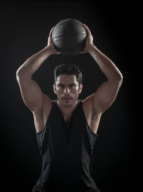 istock Man Passing a Basketball On A Black Background 695010124
