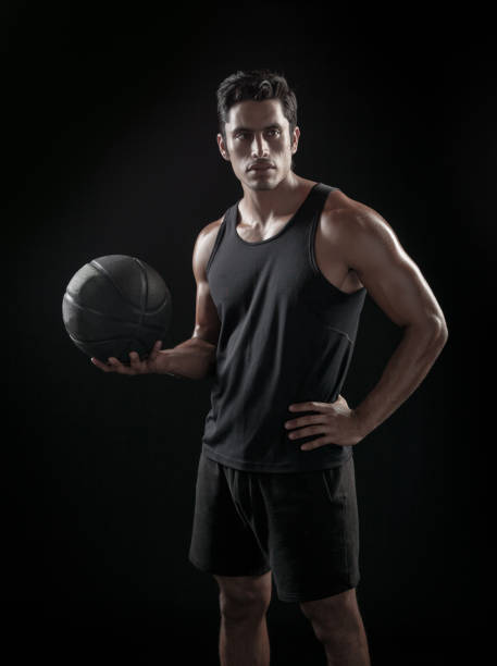 istock Man Holding a Basketball On A Black Background 695012242
