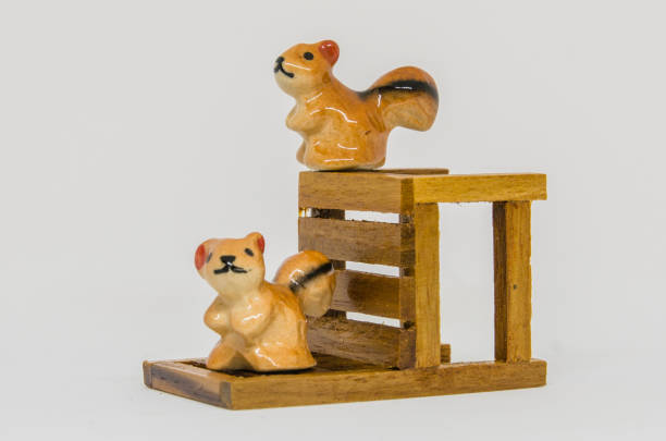 istock Squirrel Cerimic On Wooden Bench In The Park 695022344