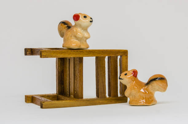 istock Squirrel Cerimic On Wooden Bench In The Park 695022352