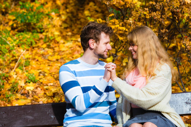 Lovers couple in autumn park on bench