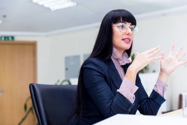 istock Female business executive using elaborate hand gestures during a job interview 695038048